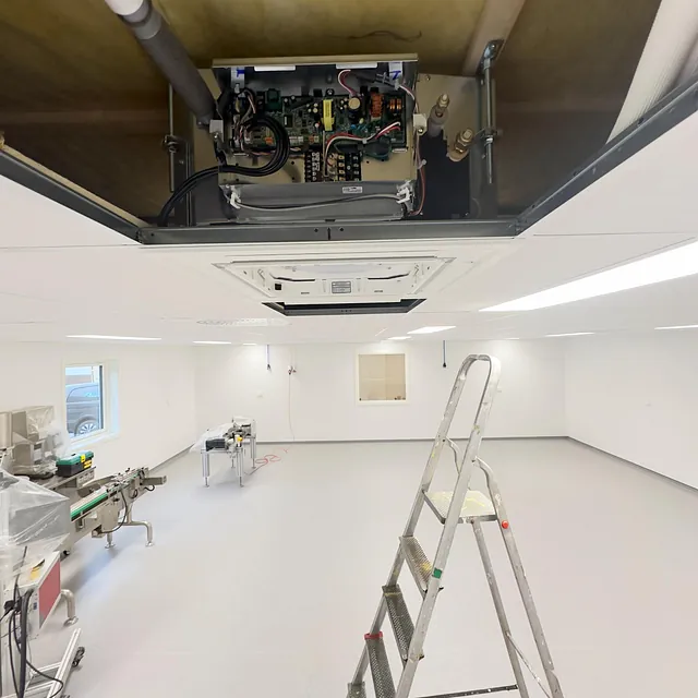 Innetak med demontert varmepumpeenhet og synlige rør og elektriske koblinger