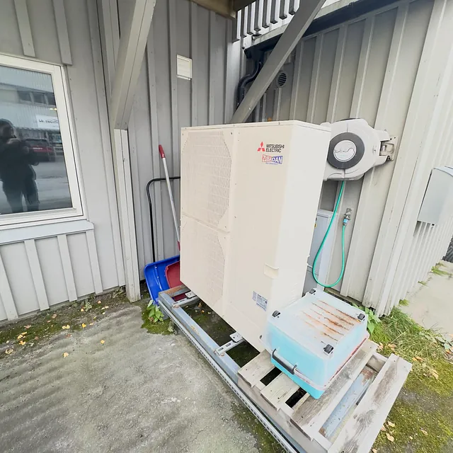 Utedel av varmepumpe ved grå husvegg